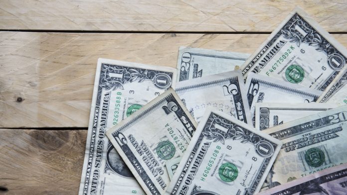 Dollar bills on wooden table, copy space